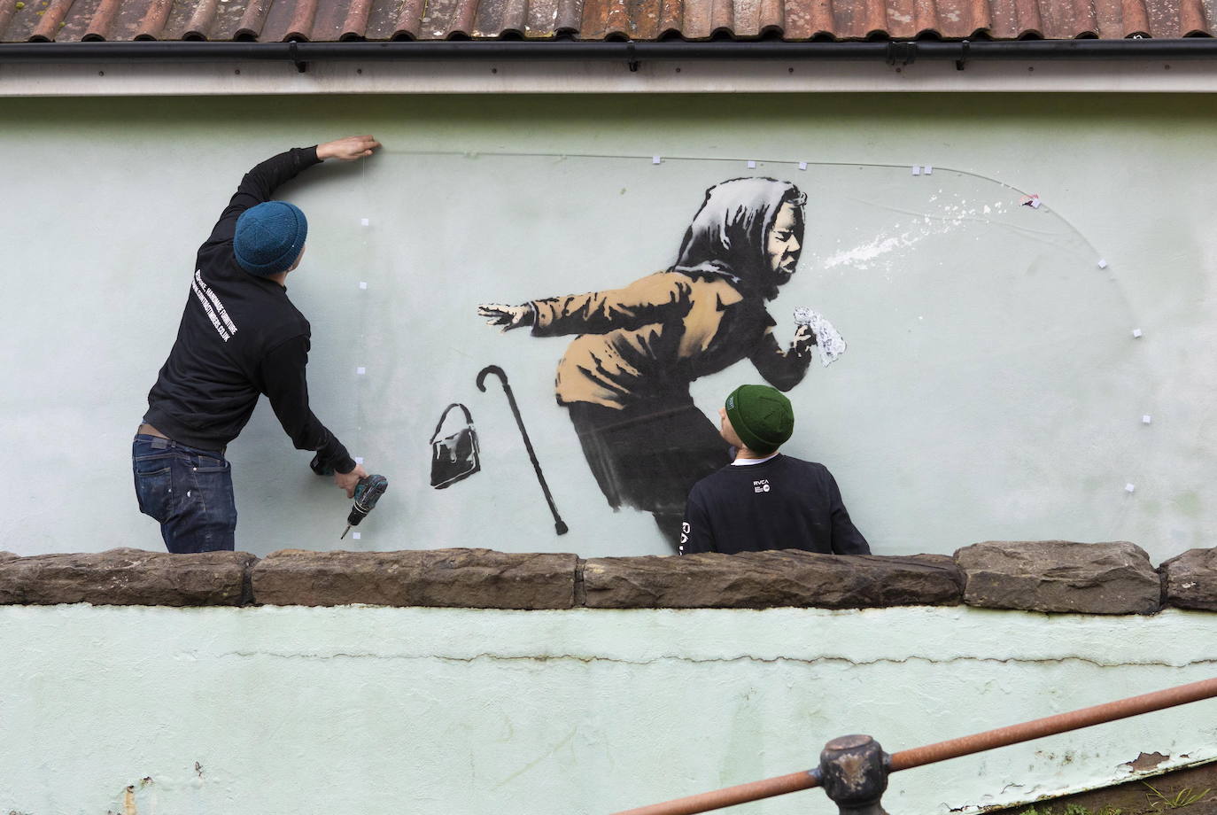 Bristol ha amanecido con una sorpresa: un nuevo mural del popular y misterioso artista urbano Banksy. La pintura titulada 'Aachoo!!' representa a una anciana estornudando, con su dentadura postiza volando, y apareció en la calle Vale Street durante la madrugada del jueves. 