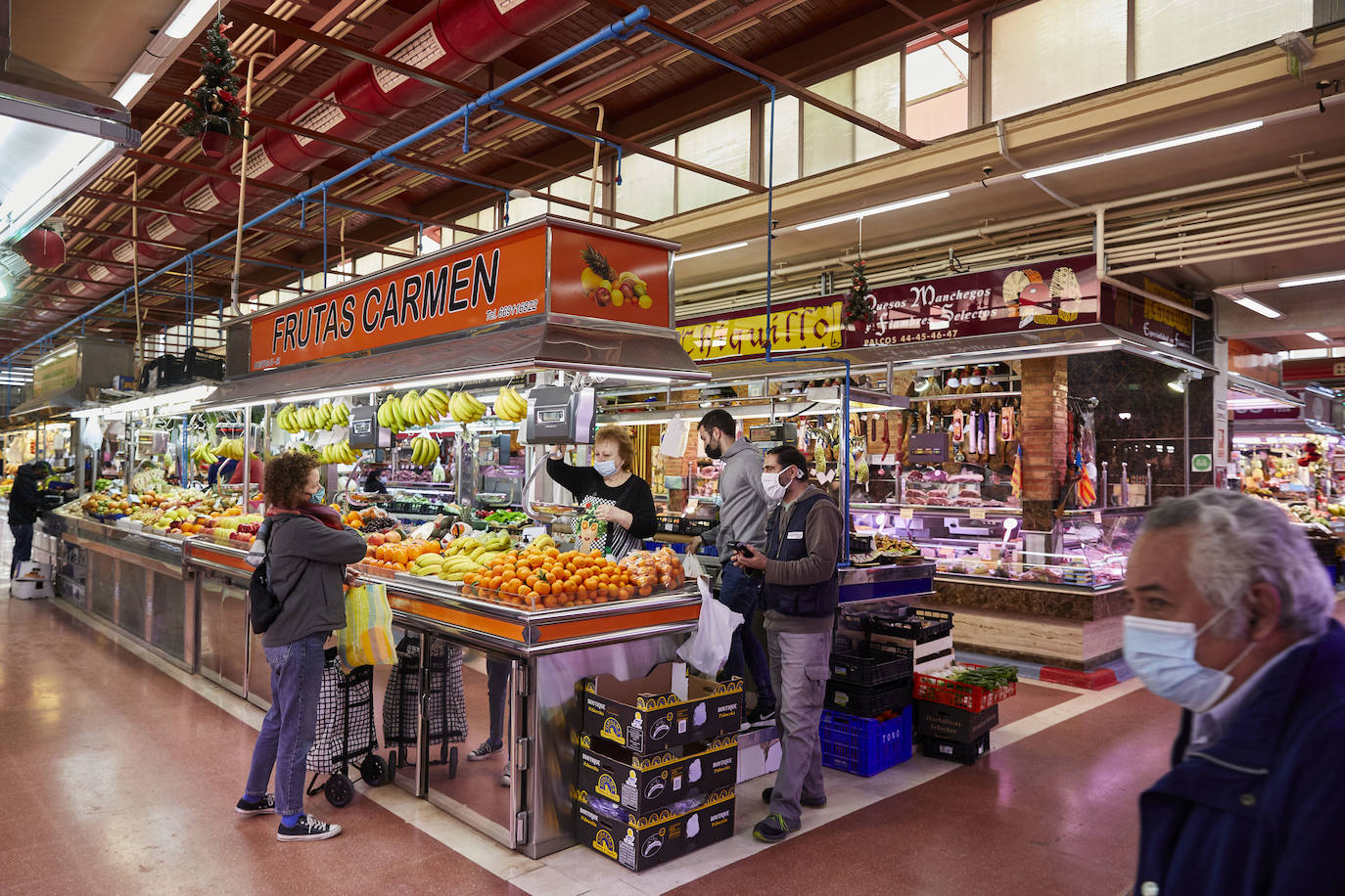 Con la Navidad a la vuelta de la esquina, los valencianos aprovechan para disfrutar del ambiente y realizar las compras en los mercados de la ciudad. La celebración de las fiestas navideñas este año será atípicas y con restricciones por la pandemia del coronavirus. En imagen, el Mercado Central de Valencia este martes.