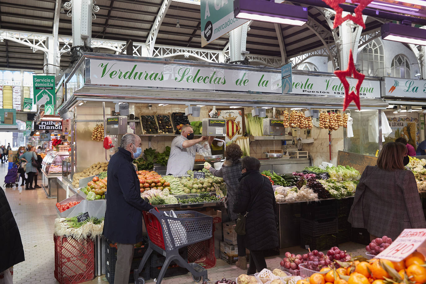 Con la Navidad a la vuelta de la esquina, los valencianos aprovechan para disfrutar del ambiente y realizar las compras en los mercados de la ciudad. La celebración de las fiestas navideñas este año será atípicas y con restricciones por la pandemia del coronavirus. En imagen, el Mercado Central de Valencia este martes.