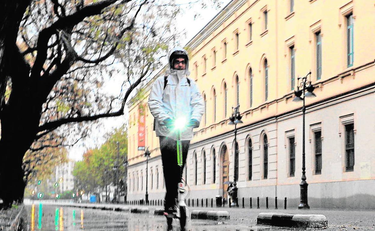 El usuario de un patinete, un día de lluvia de Valencia.