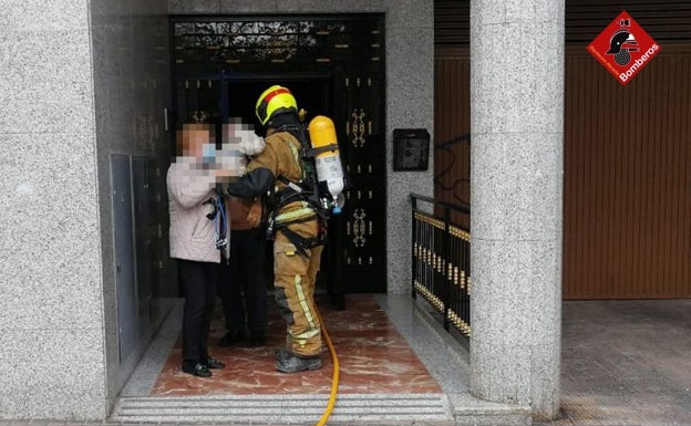 Un bombero entrega a la niña pequeña a un familiar. 