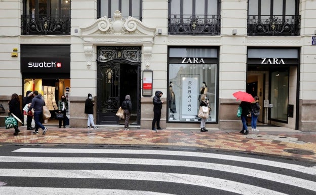 Gente esperando para acceder a una tienda de ropa en Valencia