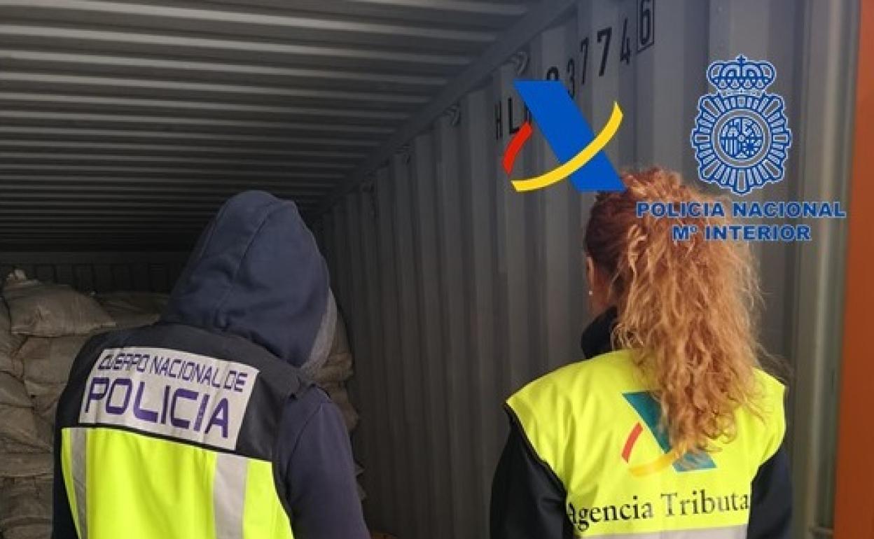 Dos agentes de laPolicía Nacional custodian el cargamento de cocaína descubierto en una nave de Alcàsser. 