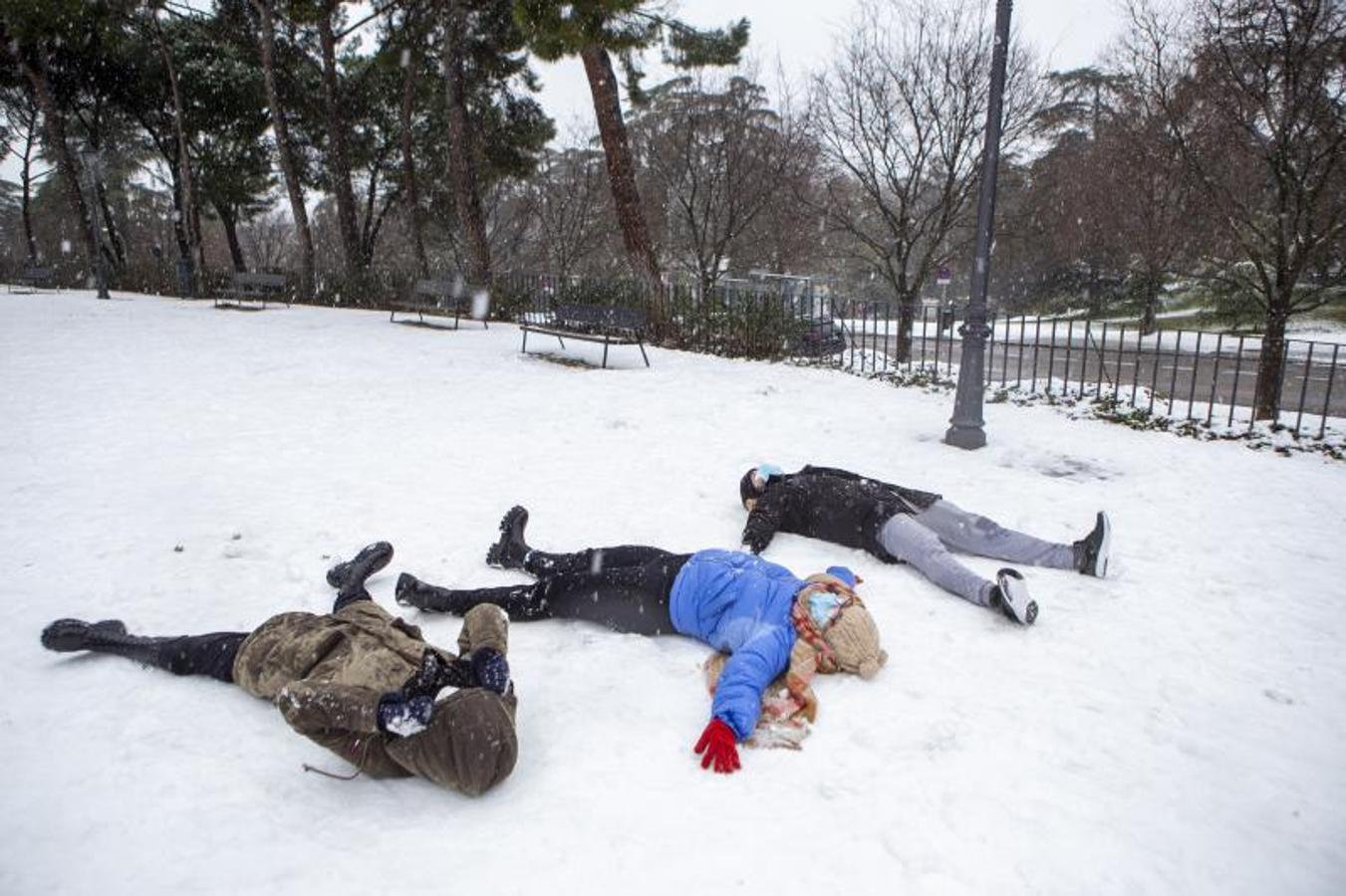 Tres personas juegan durante la nevada en Madrid dejada por la borrasca Filomena.