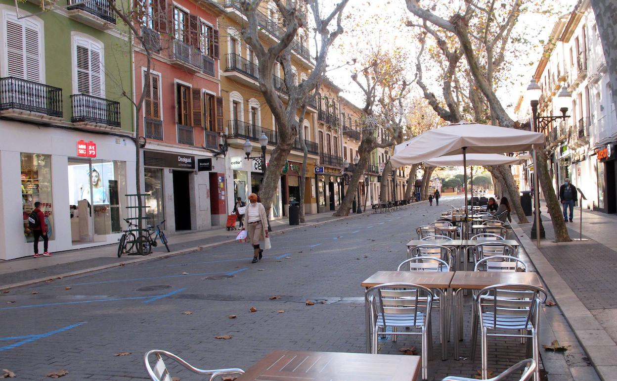Varias personas pasean por una vacía calle de Marqués de Campo en Dénia.