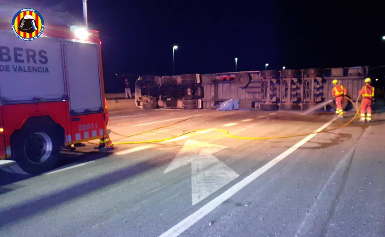 Los bomberos limpiando la carretera tras el accidente. 