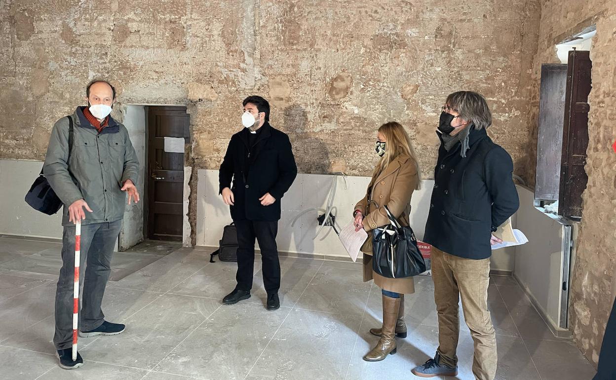 El párroco, Javier Grande, los responsables del estudio de arquitectura y el arqueólogo, ante el uro del siglo XV.