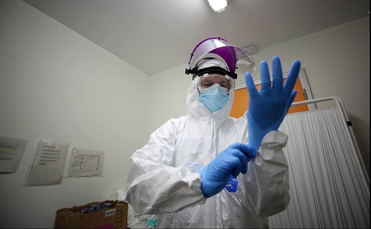 Un sanitario se pone los guantes de protección en un hospital de Valencia. 