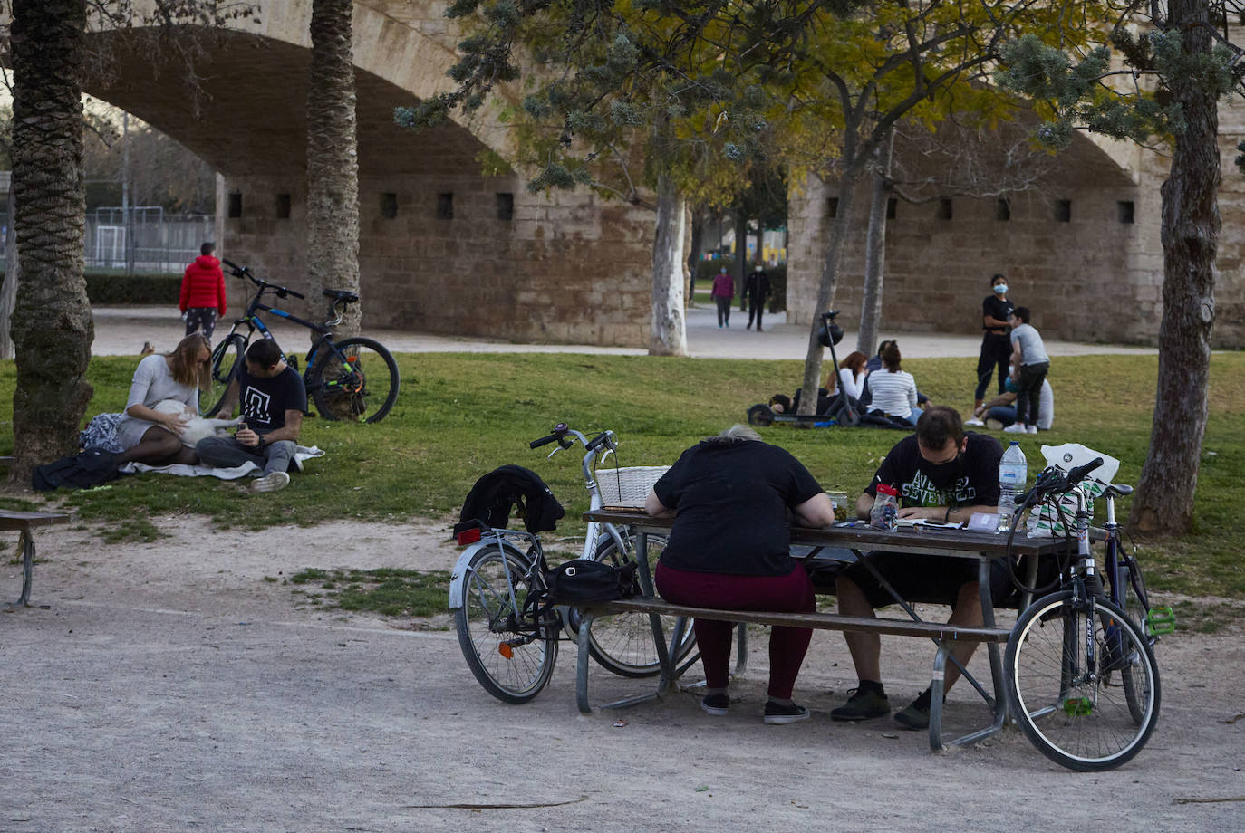 Cientos de personas bajan a diario al viejo cauce tras el cierre de los bares. Comer en el césped, entrenamiento físico o quedar con amigos son las alternativas de recreo en una ciudad sin gimnasios ni restaurantes abiertos. 