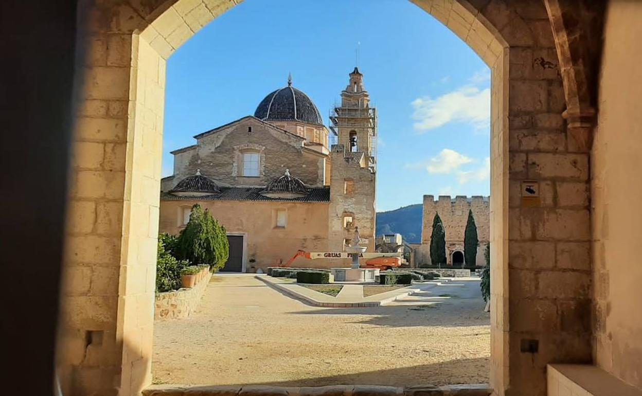 Un andamio en la torre y una grúa en el interior del monasterio de Simat. 