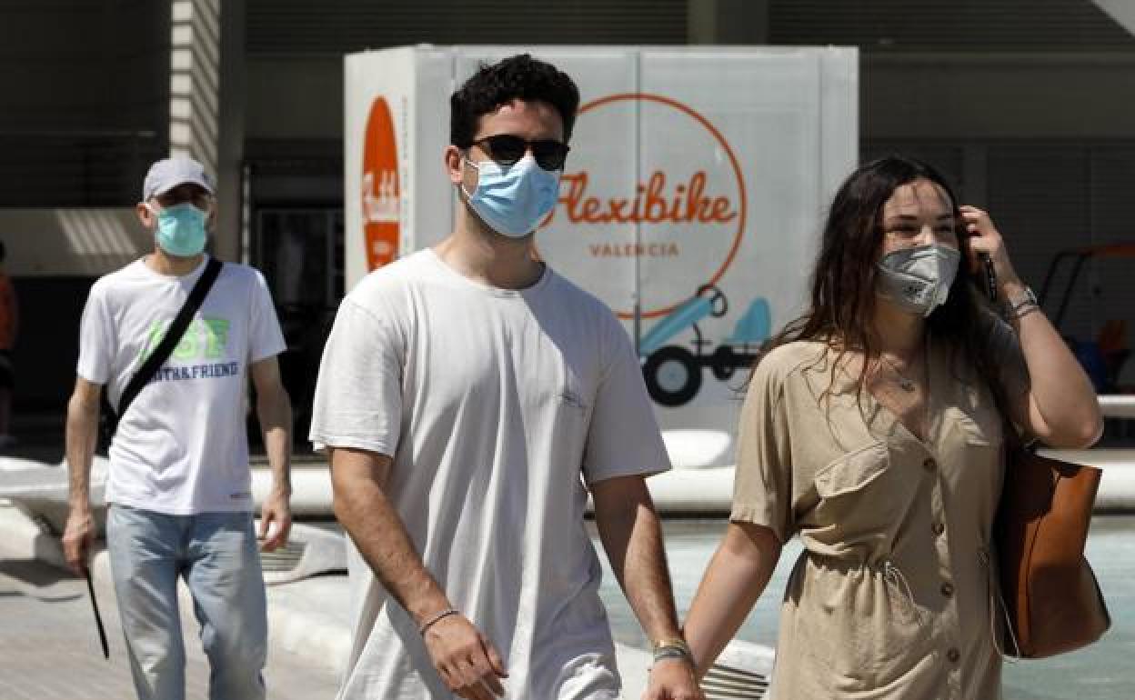 Transeuntes con mascarilla en Valencia. 