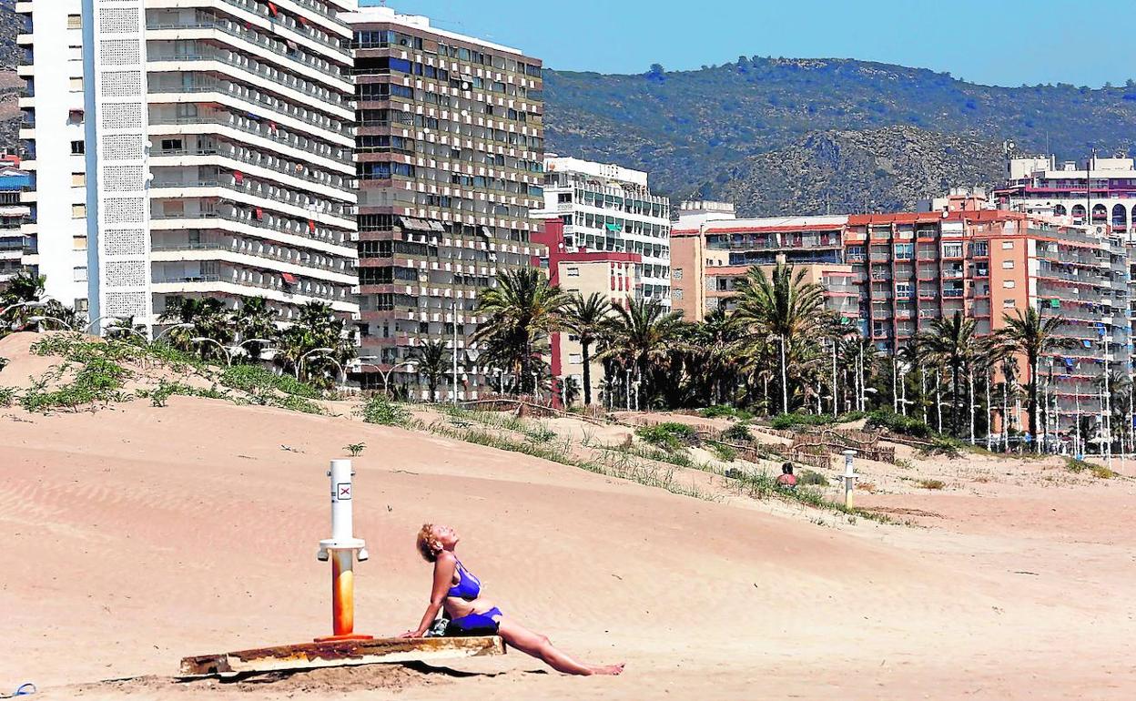 Una bañista toma el sol en la playa de Cullera. 