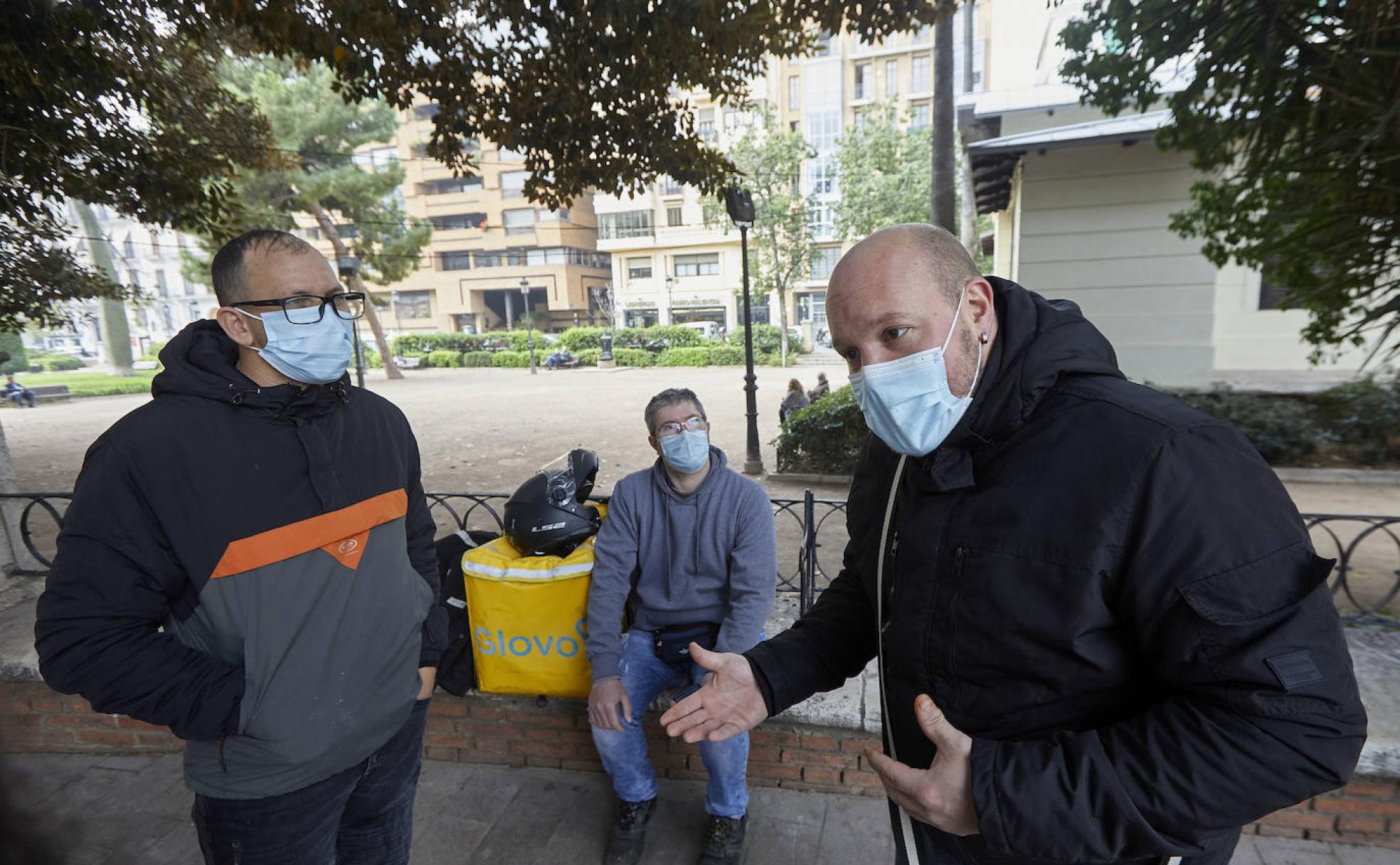 El debate. Los tres repartidores, antes de empezar su jornada, hablan sobre la futura ley en el Parterre, en Valencia.