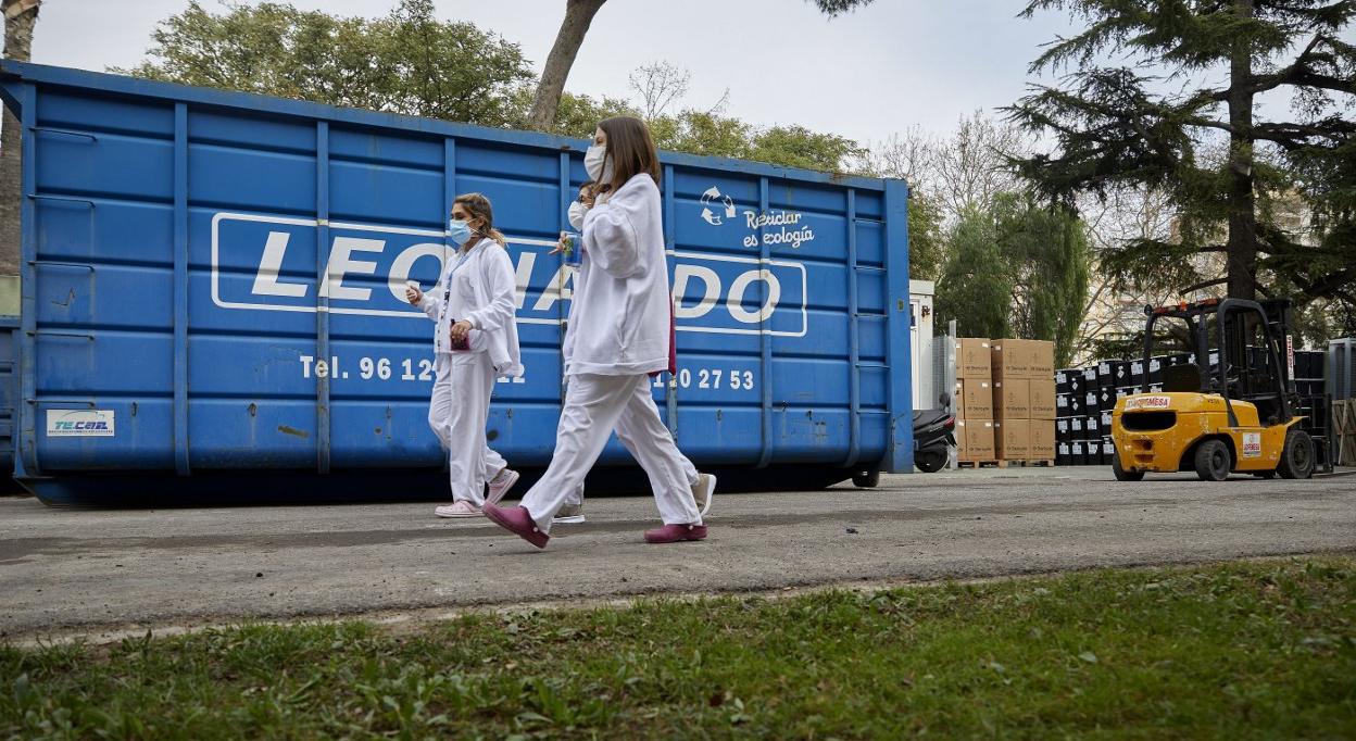 Un par de sanitarias pasan por la zona de almacenamiento de residuos del Hospital General. iván arlandis
