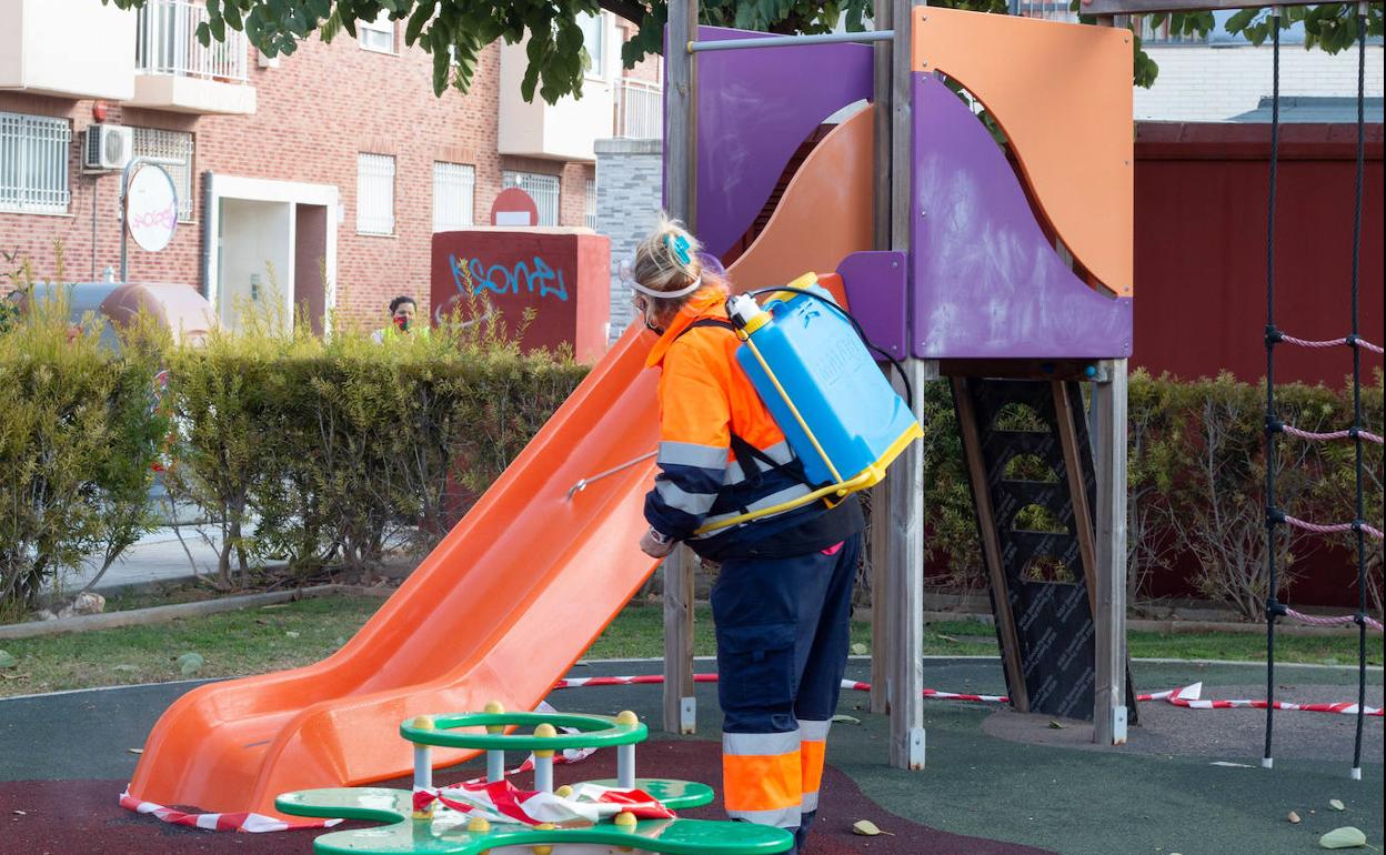 Una trabajadora desinfecta un juego de un parque infantil de Alfafar. 