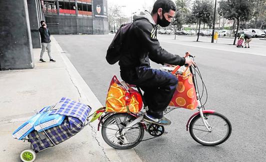 José Luis lleva en la bicicleta la comida para su familia.