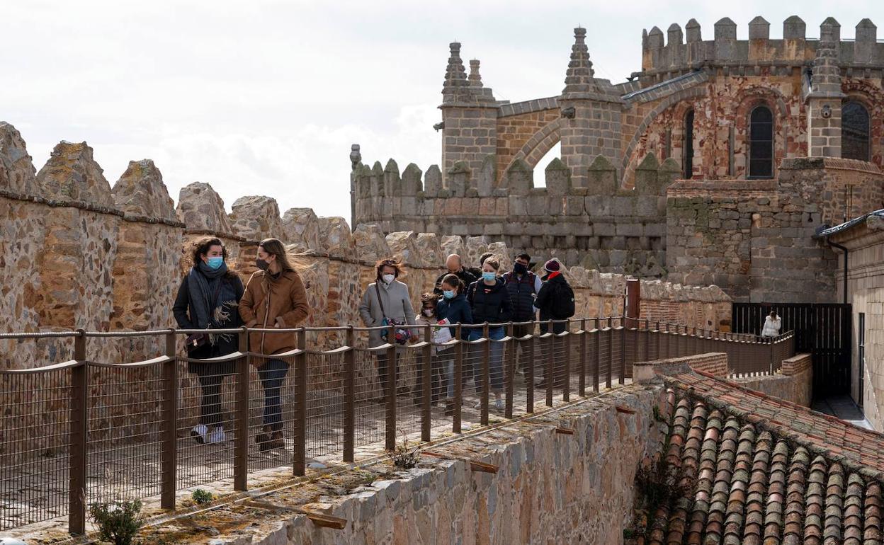 Varios turistas visitan la muralla de Ávila, que en febrero reabrió al público tras cerrar durante más de un mes por la pandemia.