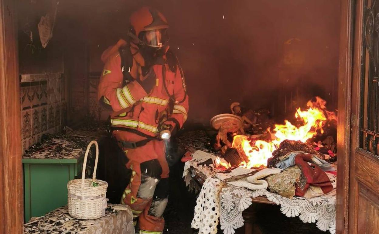 Los bomberos trabajan en el incendio de una casa en Massanassa. 