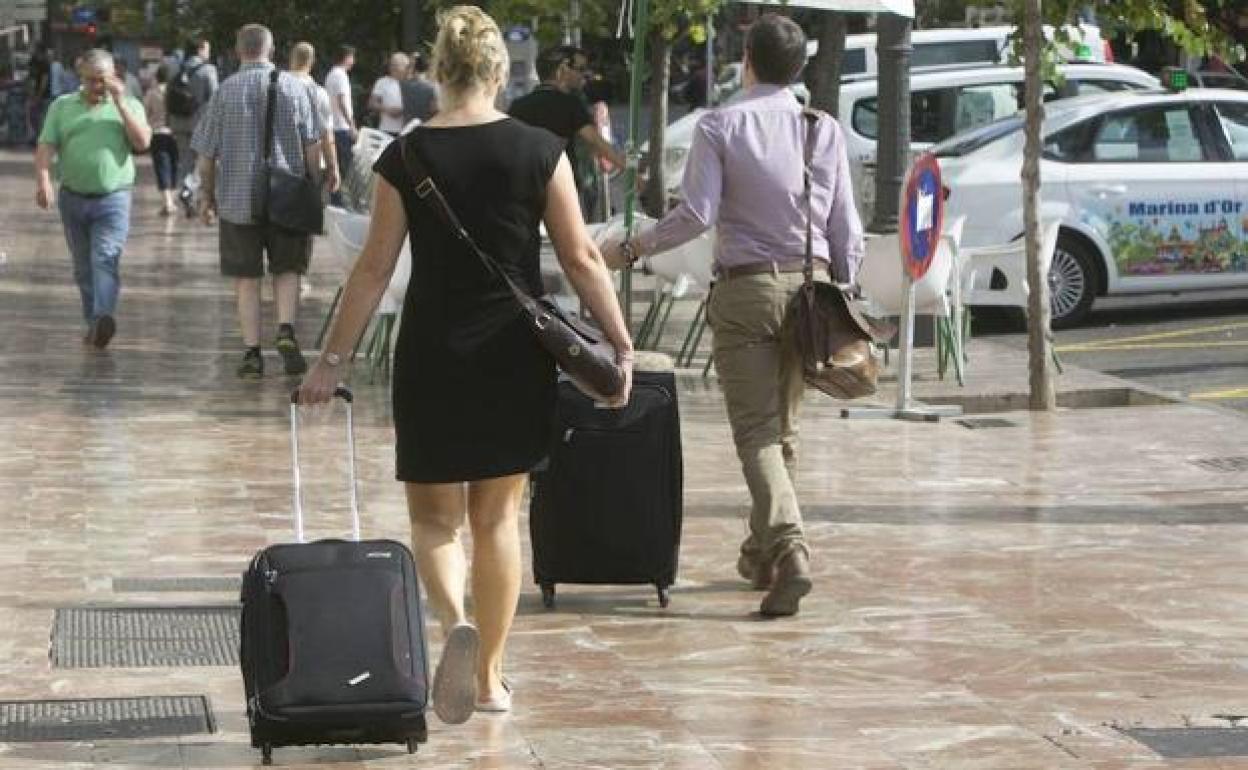 Turistas, con sus maletas, en el centro de Valencia