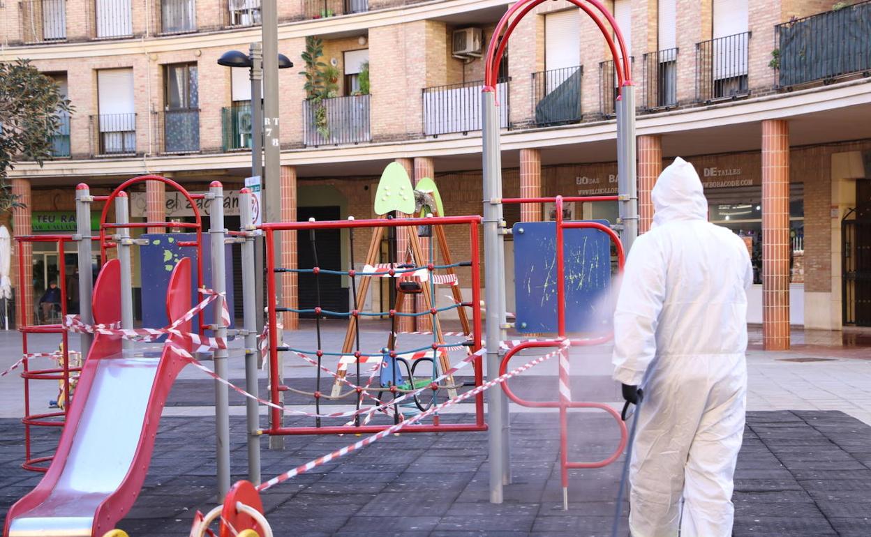 Un trabajador desinfecta una parque infantil. 