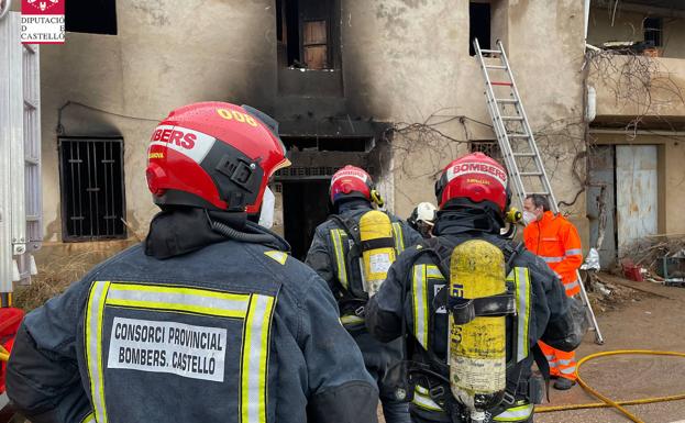 Los bomberos trabajan en el incendio de la vivienda.