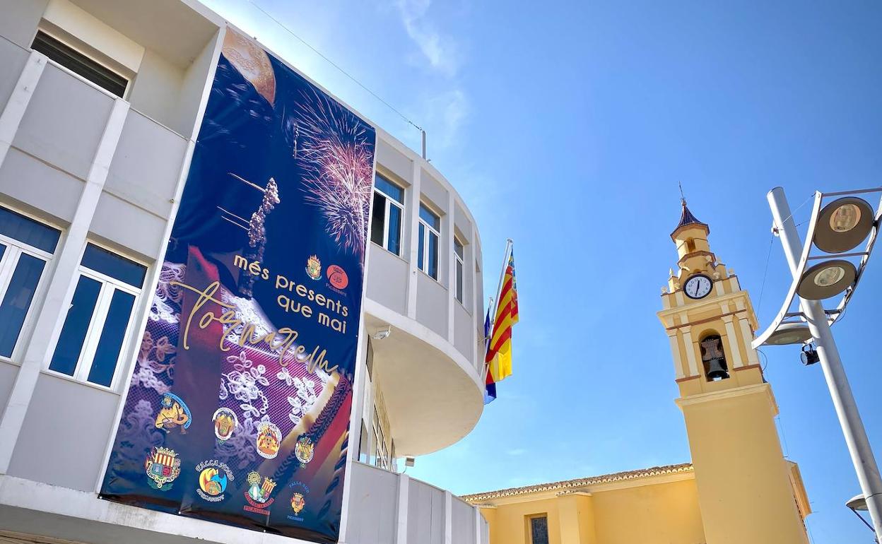 El cartel de Fallas cuelga de la fachada de las dependencias municipales de Picassent. 