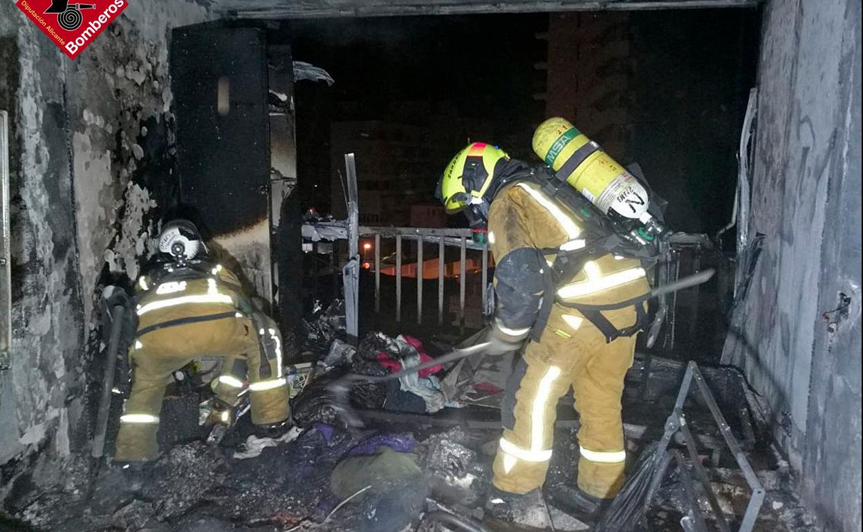 Dos bomberos trabajan en las tareas de extinción del incendio de esta vivienda en Benidorm. 