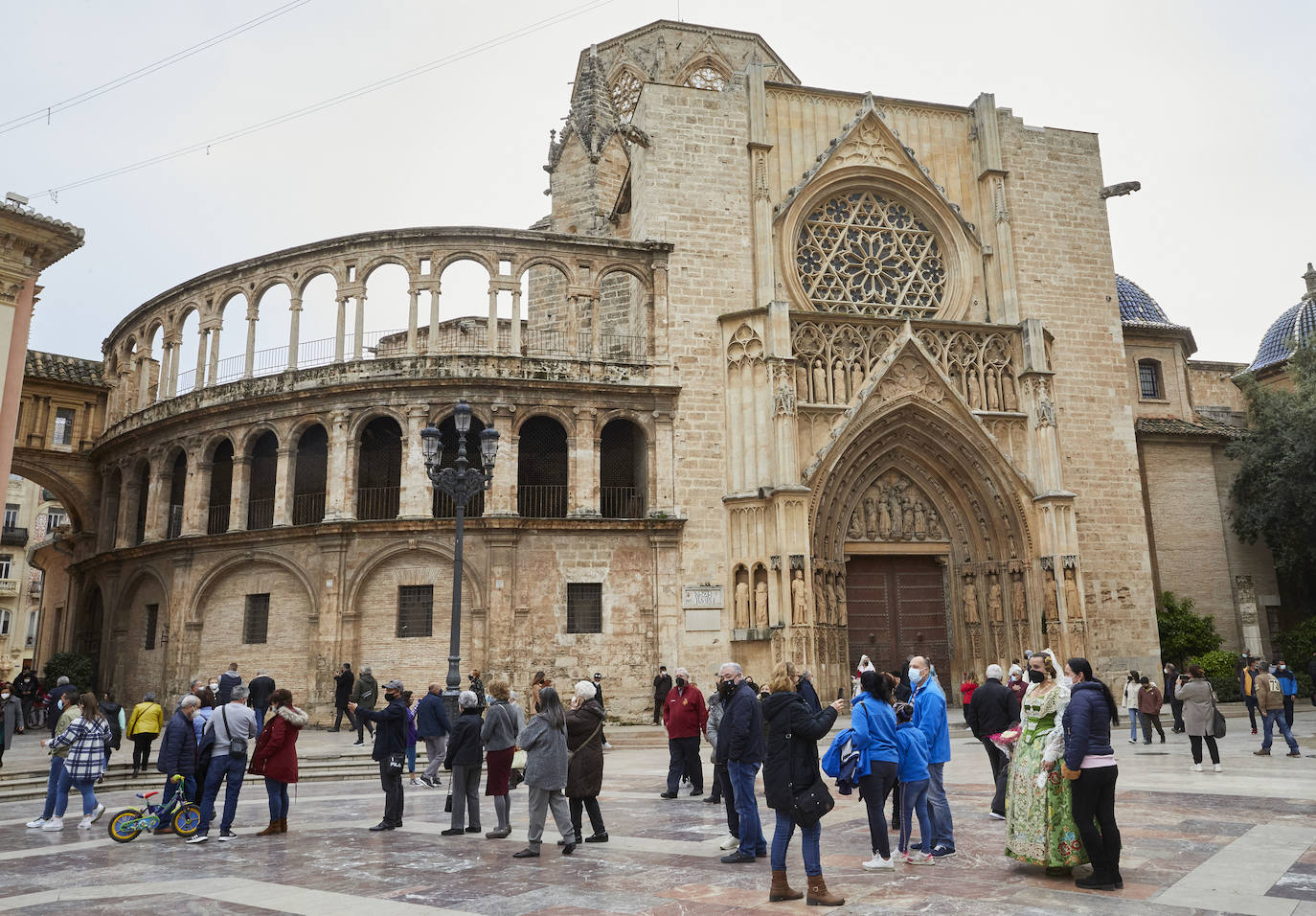 Decenas de personas acuden a la misa de la Catedral y también vestidas de fallera a la Basílica de la Virgen