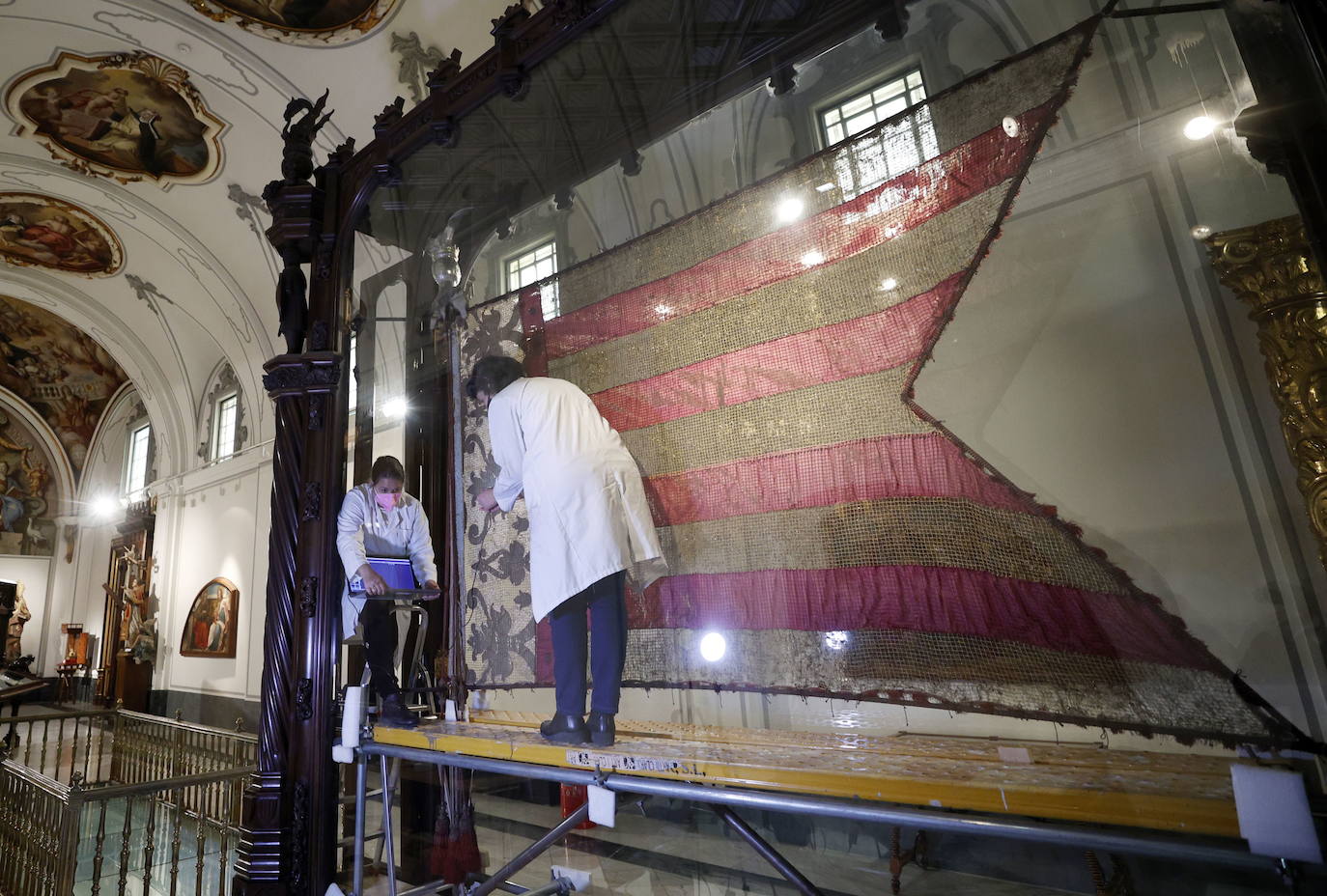 Técnicos toman muestras del estandarte para restaurarlo y preparar la nueva imagen del icono de los valencianos.