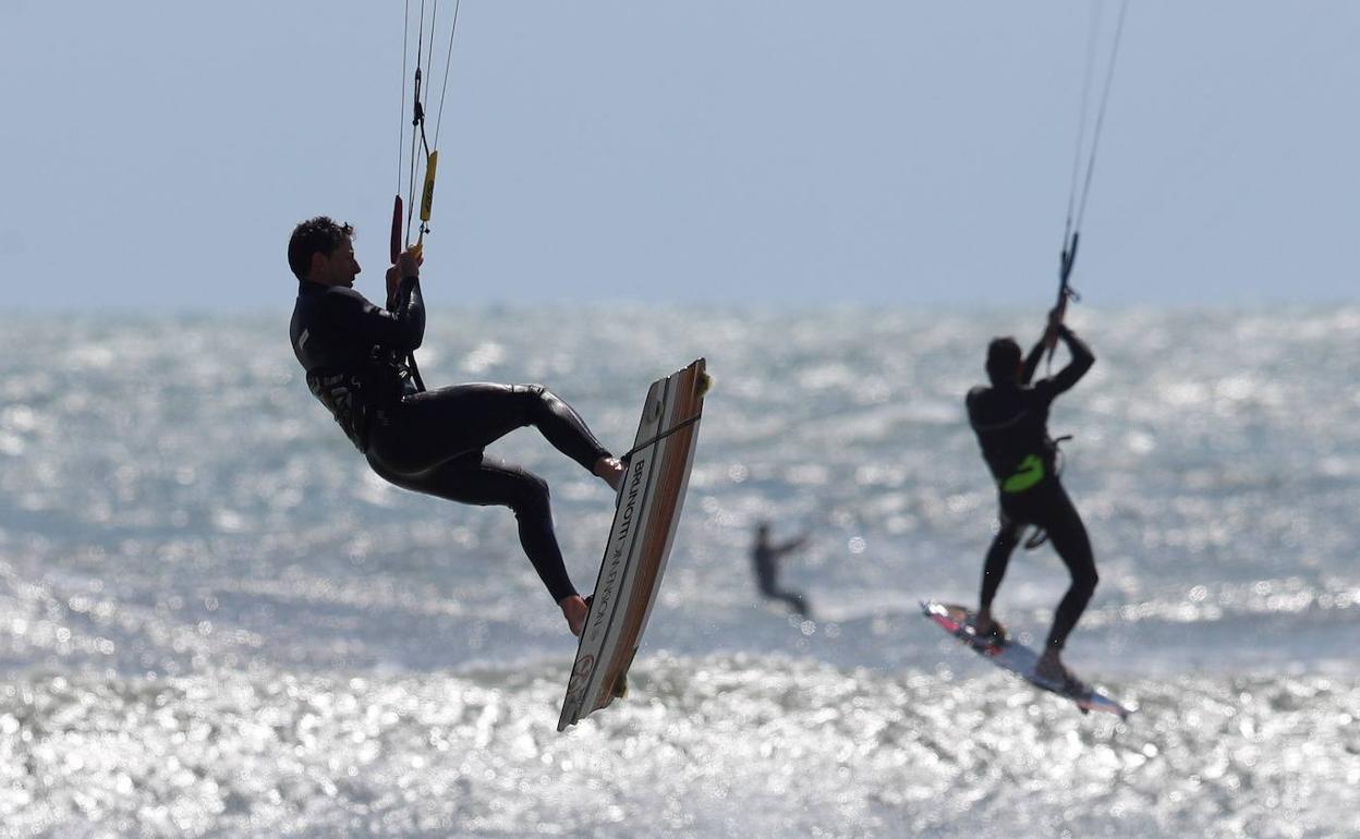 Los kitersurfistas aprovechaban el viento de este sábado para navegar en Valencia. 