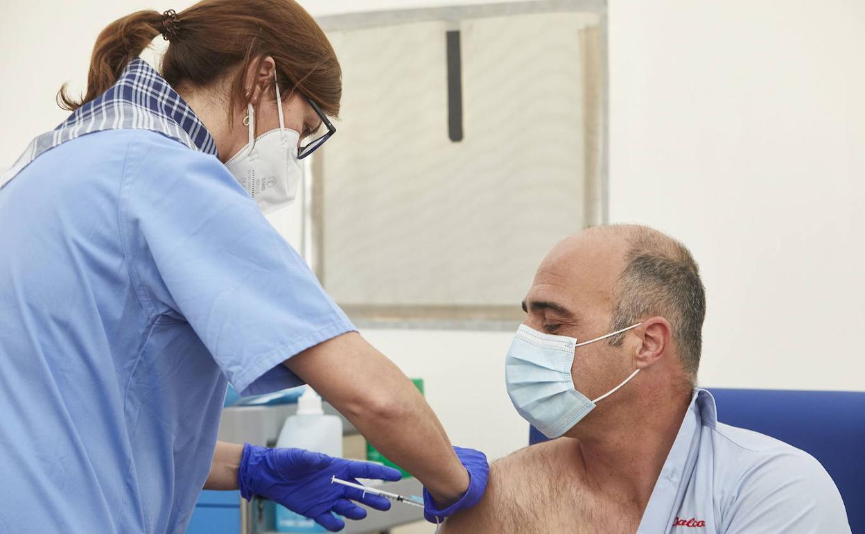 Una sanitaria vacuna a un docente en Valencia.