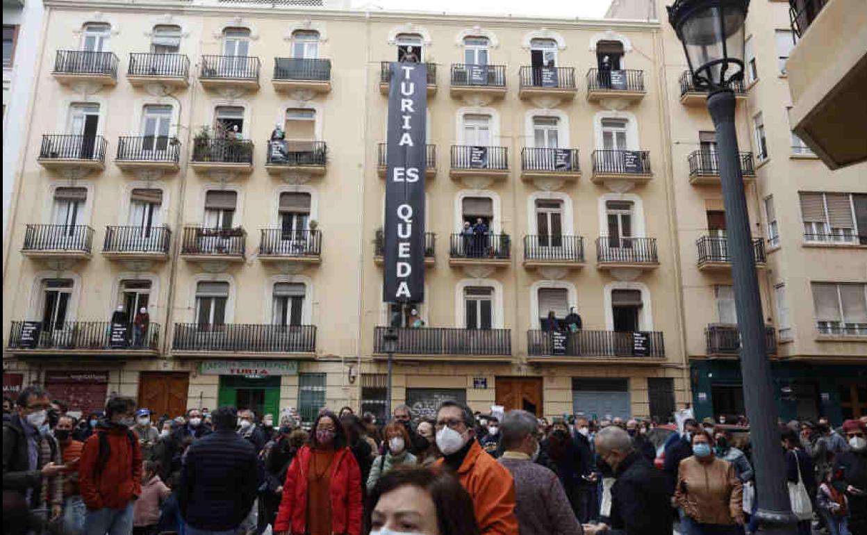 Vecinos amenazados por el desalojo, esta mañana, junto a la pancarta de protesta.