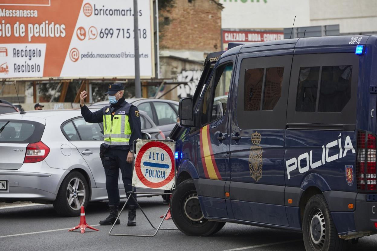 Un agente de la Policía Nacional vigila el cierre permitral de los municipios más poblados durante el pasado mes de febrero, en Valencia. I. ARLANDIS