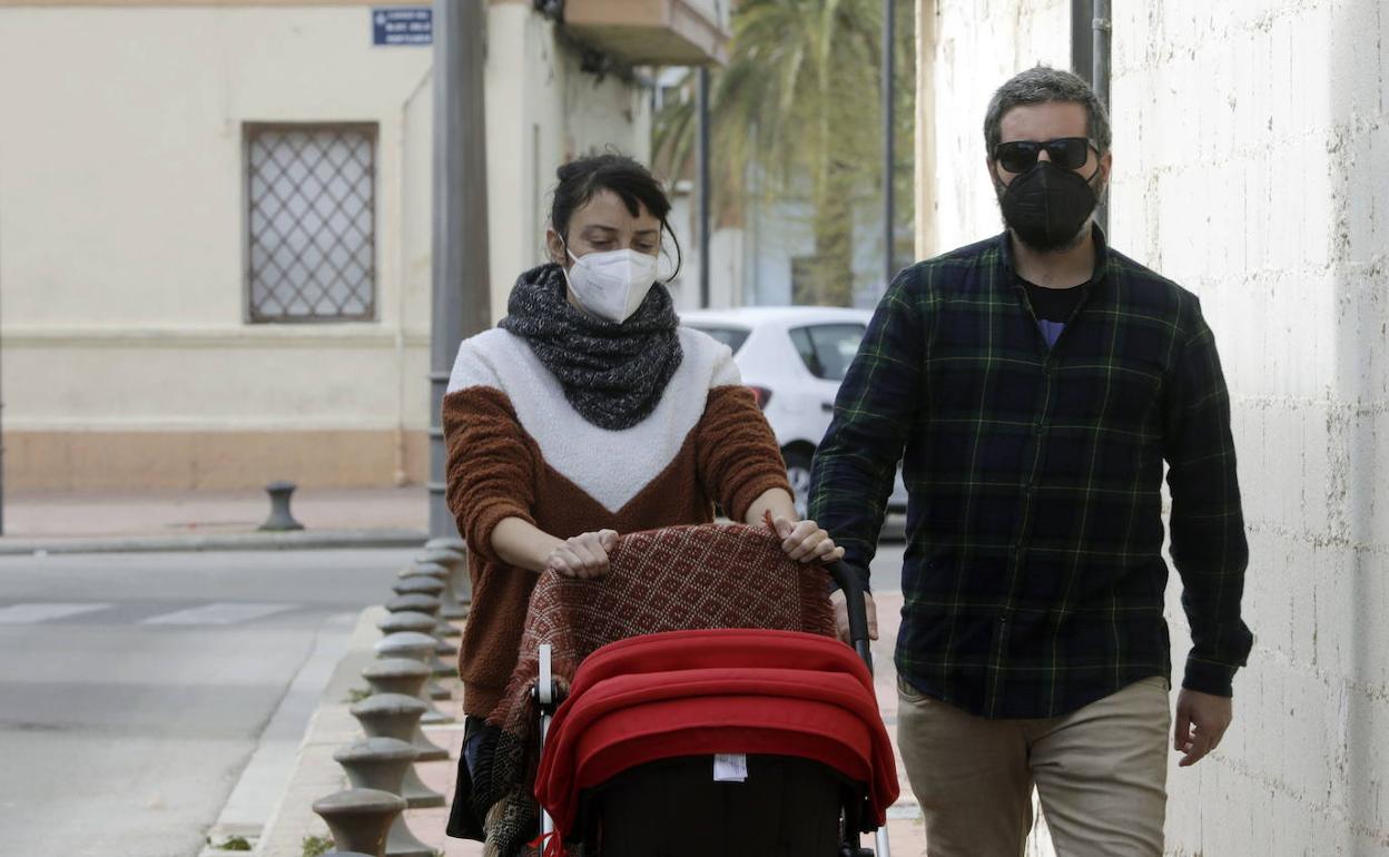 Personas paseando por Valencia con mascarilla. 