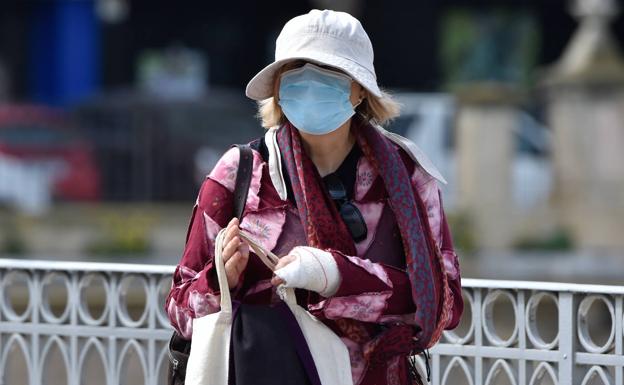 Una mujer con mascarilla. 