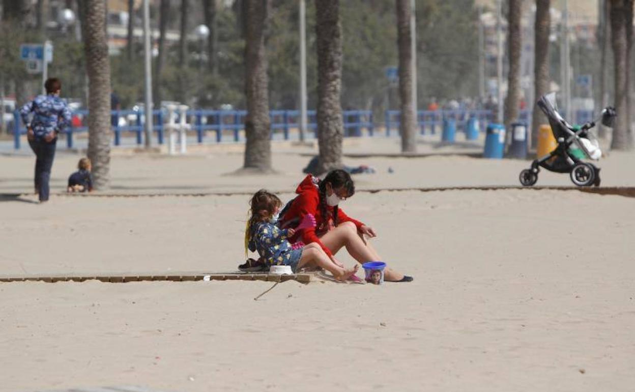 Un padre juega con su hija este miércoles en la playa del Postiguet de Alicante. 