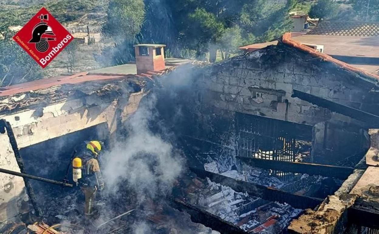 Los bomberos extinguen el incendio que ha calcinado por completo la vivienda. 