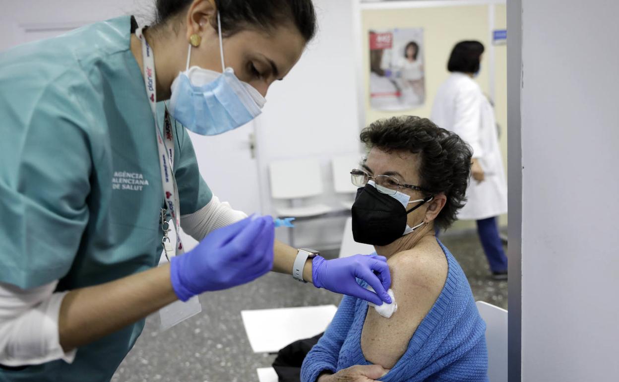 Personal sanitario vacuna a una persona en un centro de salud valenciano.