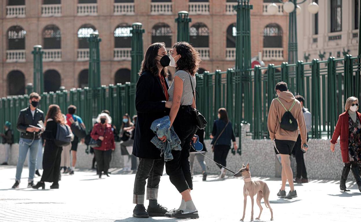 Varias personas por el centro de Valencia con mascarilla. 