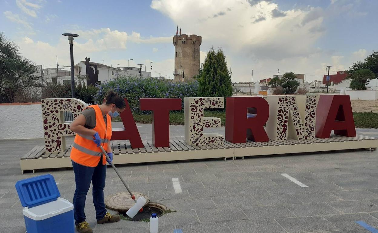 Una trabajadora toma una muestra de las aguas residuales. 