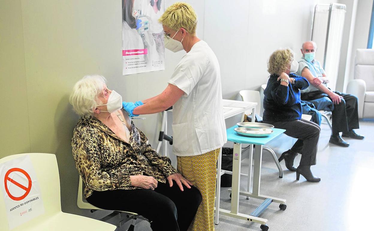 Una enfermera vacuna a una paciente en un centro de salud de Valencia. 