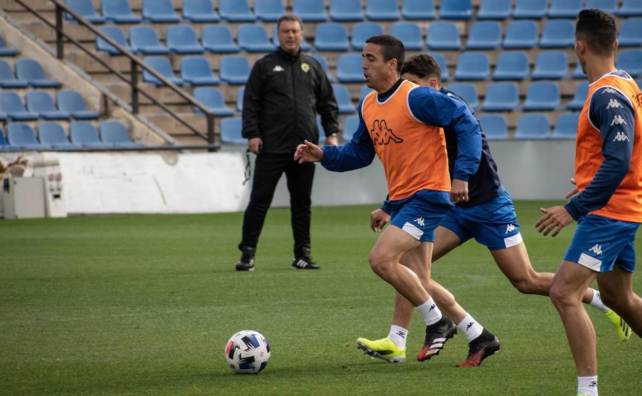 Pedro conduce el balón en un entrenamiento de esta semana ante la mirada de Manolo Díaz. 