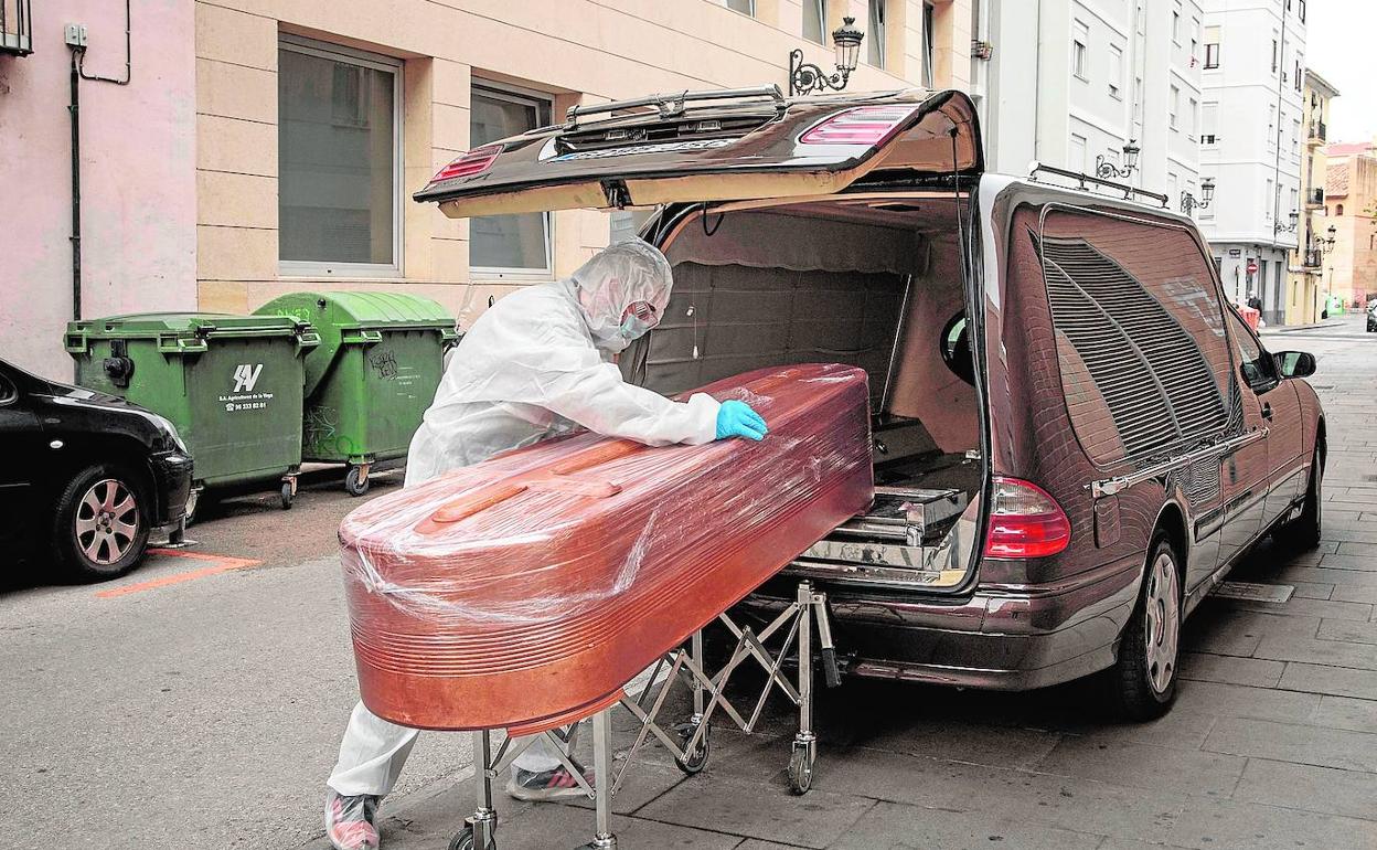 Un empleado coloca, en diciembre pasado, un féretro de una residencia en un coche de difuntos.