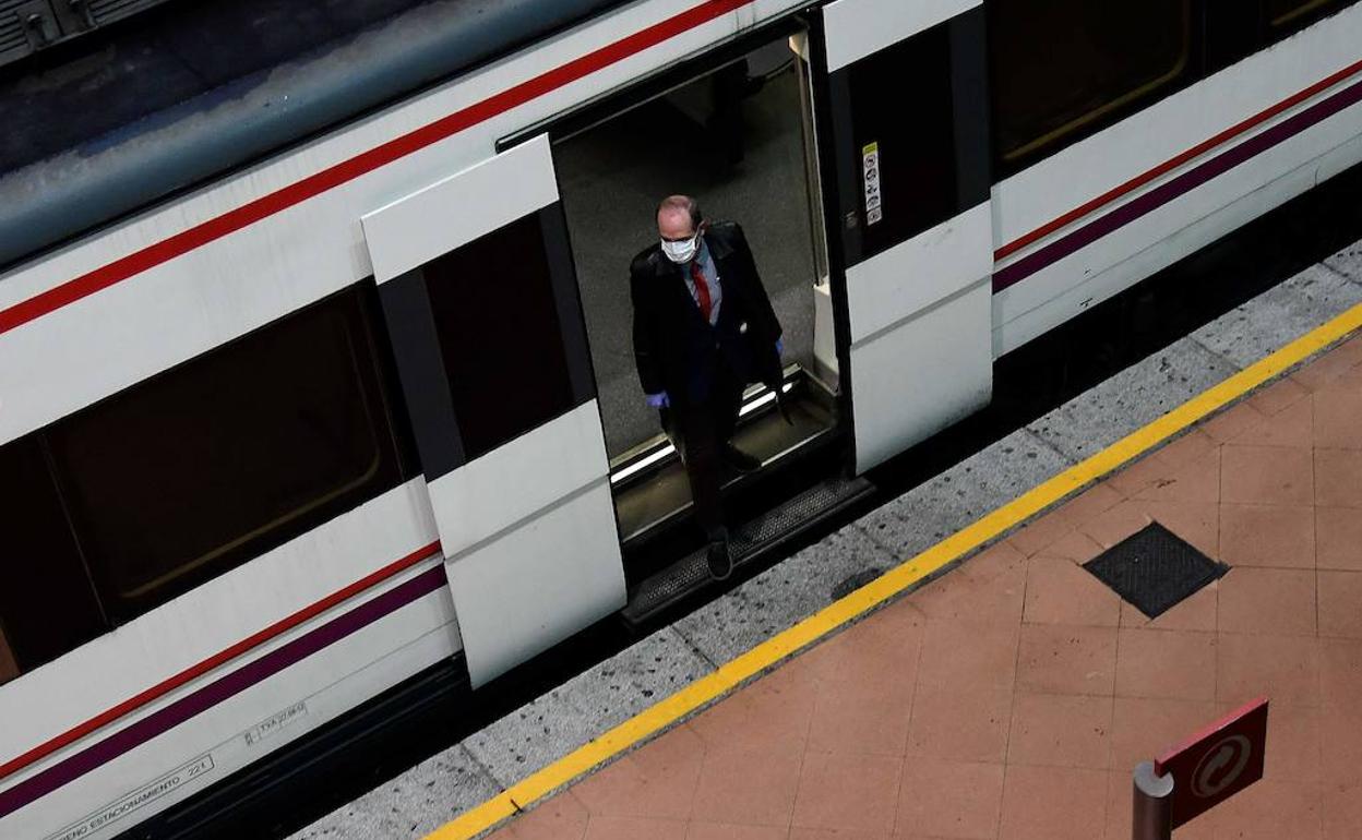 Un hombre sale de un tren en una estación de España.