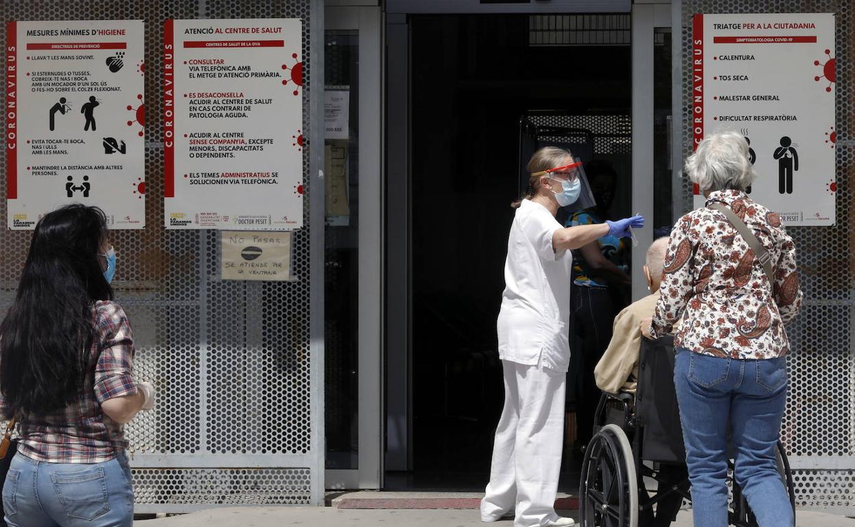 Un sanitario regula la entrada a un centro de salud. 