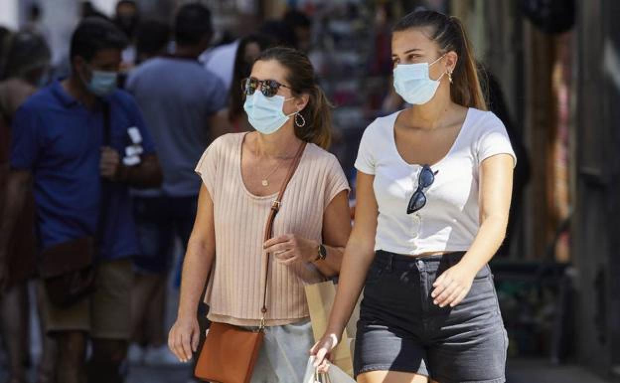 Dos mujeres con mascarilla pasean por el centro de Valencia.