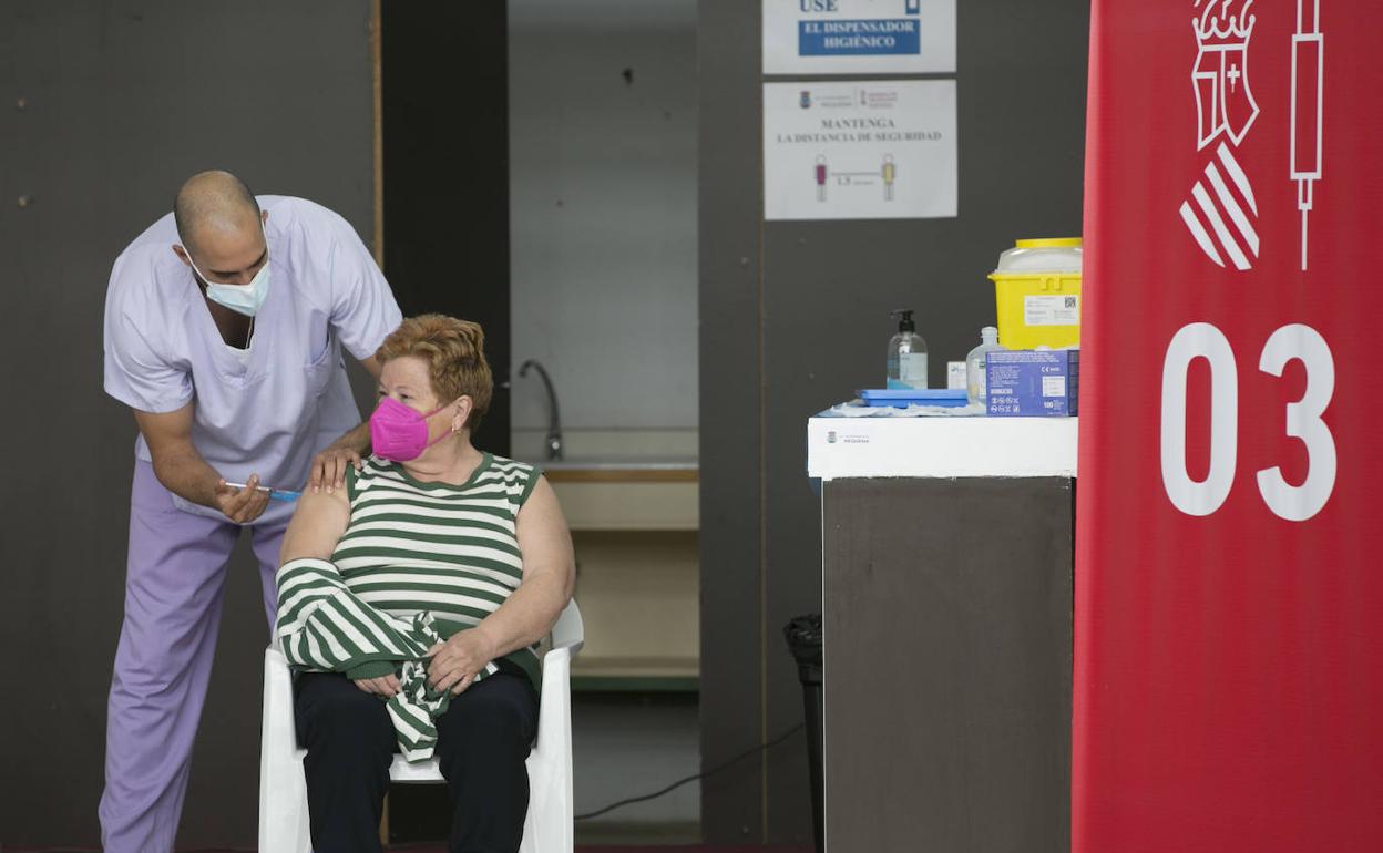 Personal sanitario administra una dosis de la vacuna contra el Covid en el recinto ferial de Requena.