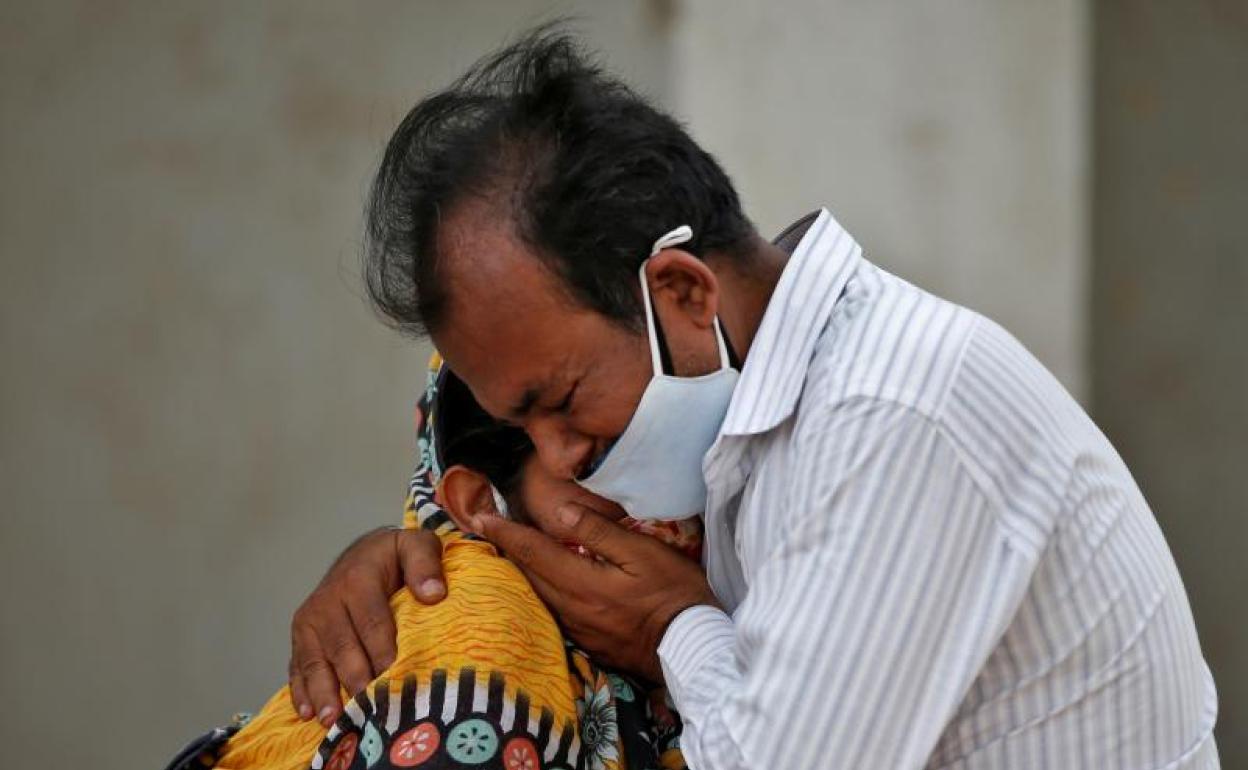 Una mujer es consolada tras la muerte de un familiar. 