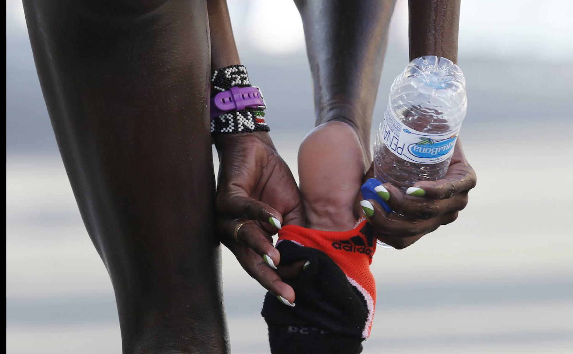 Una atleta se descalza en el Maratón de Valencia