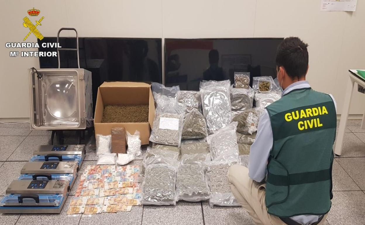 Un agente de la Guardia Civil, junto a toda la droga y el material interceptado. 